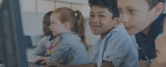 Four young students using computers.