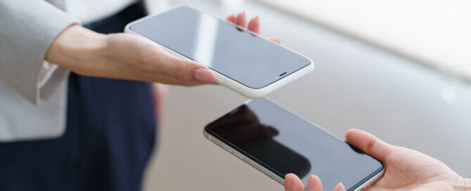 Women's hands showing each other the screen of the smartphone