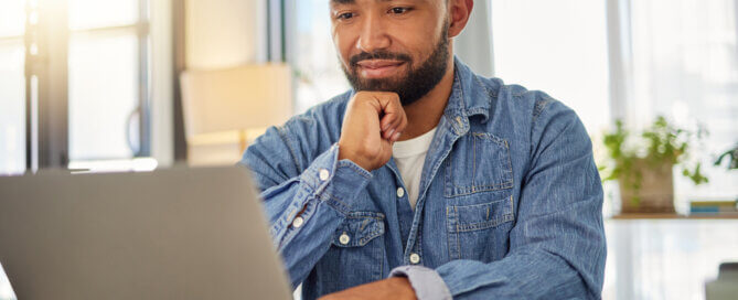 Happy businessman working on his laptop at home.