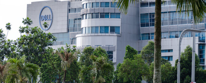 Exterior view of Dell Technologies office building, on street with palm and green trees.